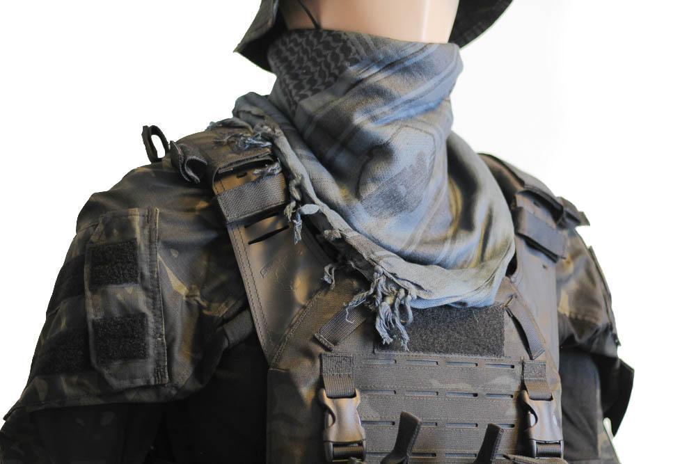 A person wearing a camouflage tactical military scarf on their head and neck.