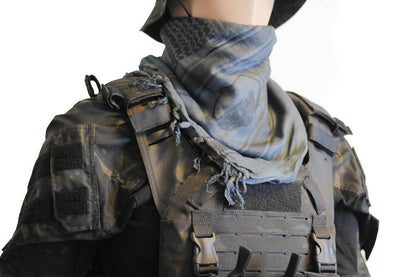 A person wearing a camouflage tactical military scarf on their head and neck.